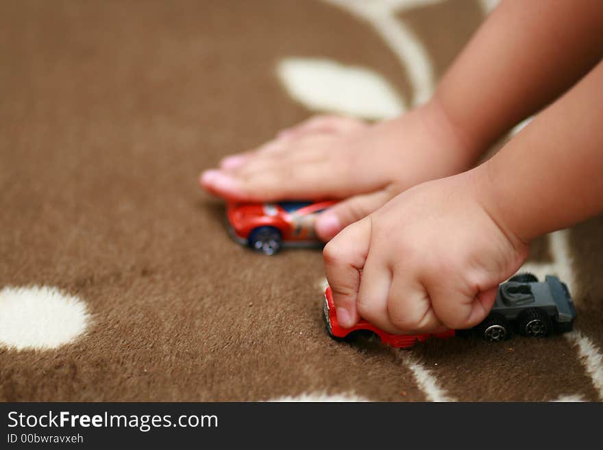 A three year old kid playing his toys. Can also be a conceptual image of competition instead of direct child's play image. A three year old kid playing his toys. Can also be a conceptual image of competition instead of direct child's play image