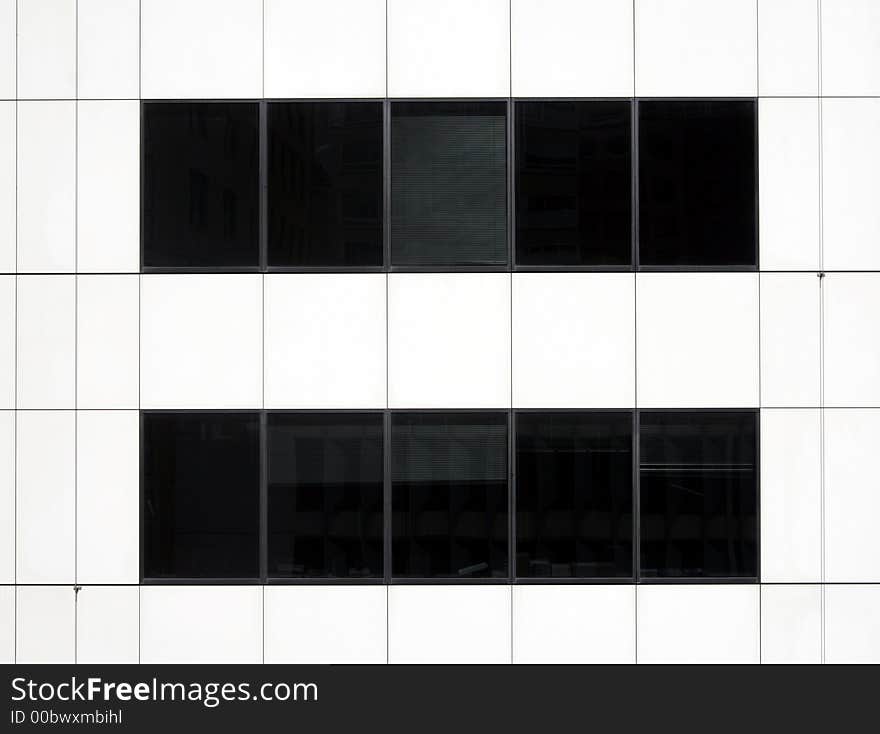 Modern Black Glass Windows In A White Urban Office Building Facade. Modern Black Glass Windows In A White Urban Office Building Facade