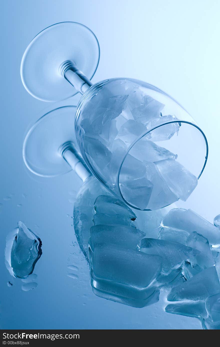 Ice cubes in a glass on a reflective surface