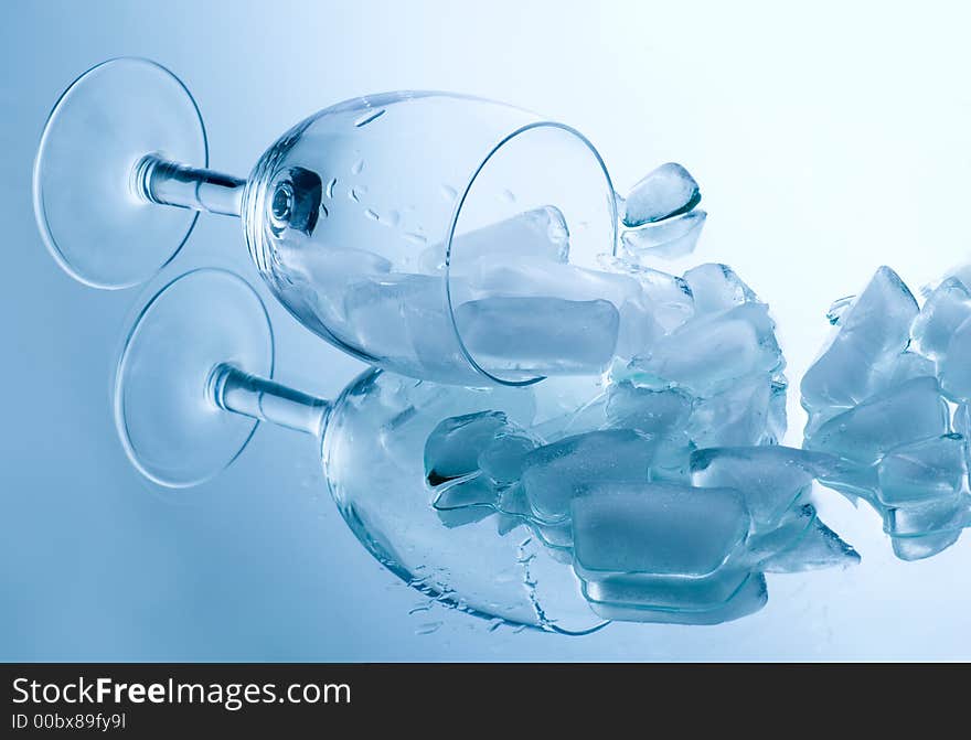 Ice cubes in a glass on a reflective surface