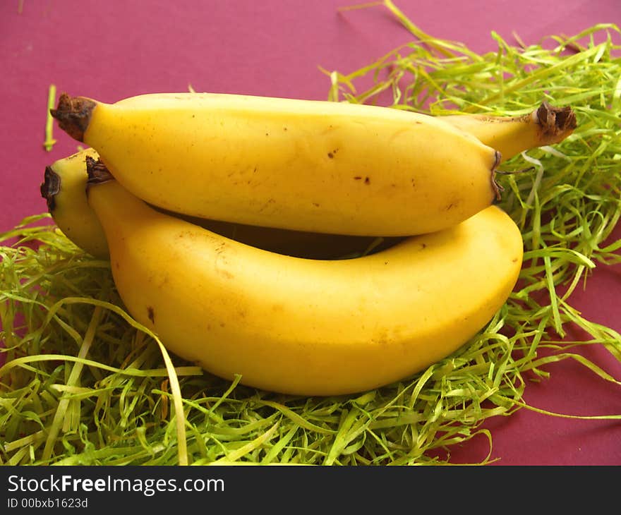 Three bananas in a pile on green paper. Three bananas in a pile on green paper