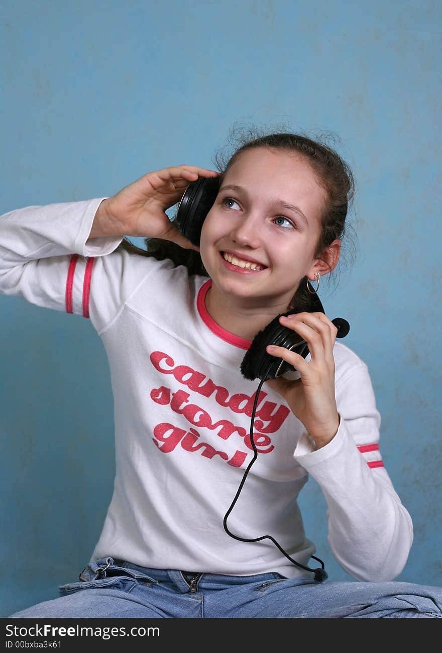 Smiling girl in headphones on a blue background