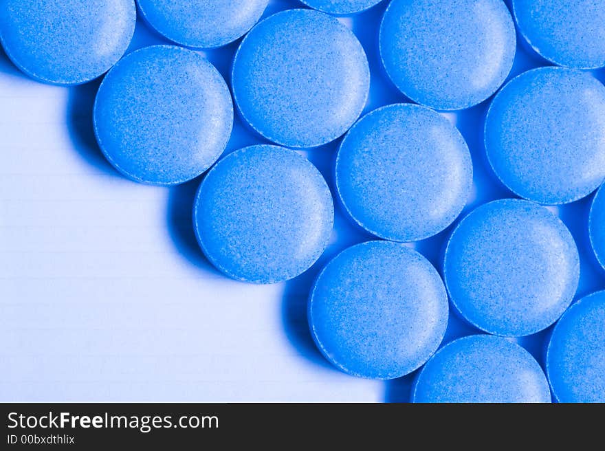 Round blue pills sit on a table.