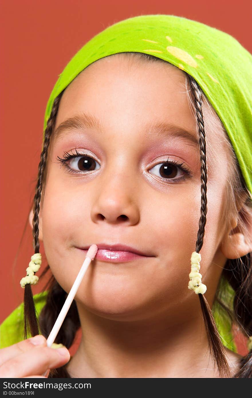 Young pretty child applying make-up