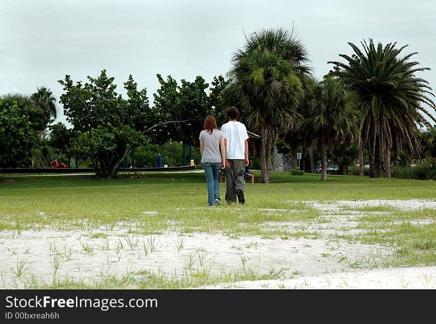 Teen couple walk in park