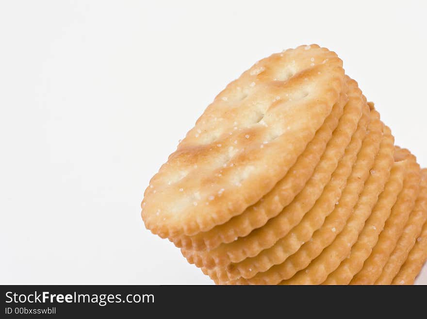 Stack of salted crackers revealing texture and detail isolated on white with room for text. Stack of salted crackers revealing texture and detail isolated on white with room for text