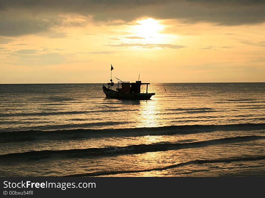 A fisherman boat in background of a sun set. A fisherman boat in background of a sun set