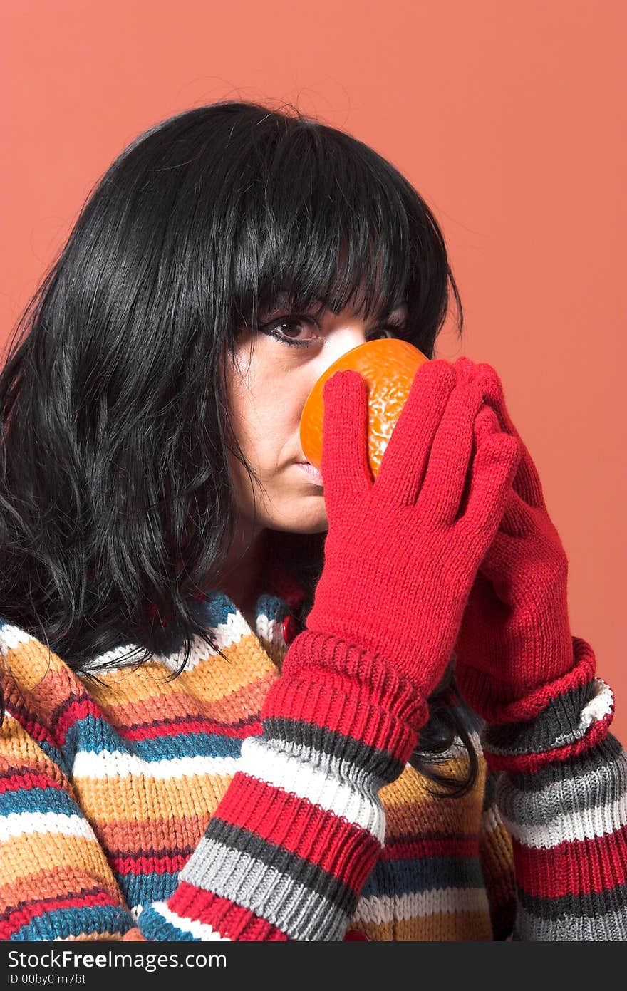 Beautiful woman in sweater dress with orange cup of tea