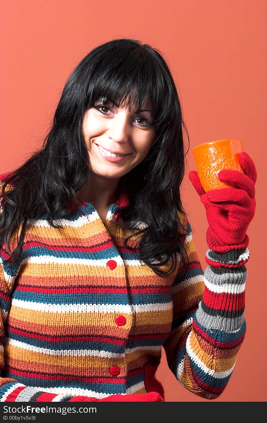 Beautiful woman in sweater dress with orange cup of tea