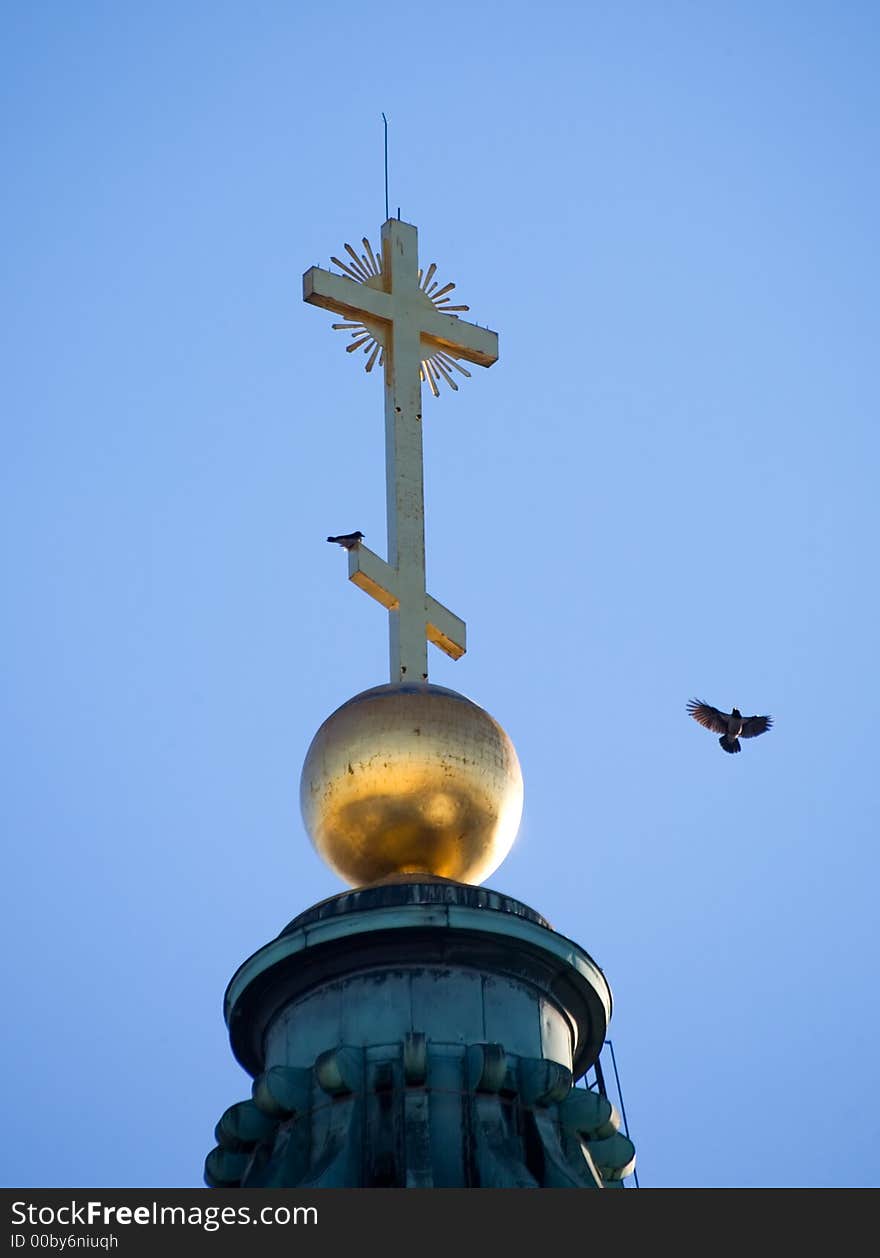 Gold cross at top of the Kazan cathedral in St.-Petersburg and birds. Gold cross at top of the Kazan cathedral in St.-Petersburg and birds