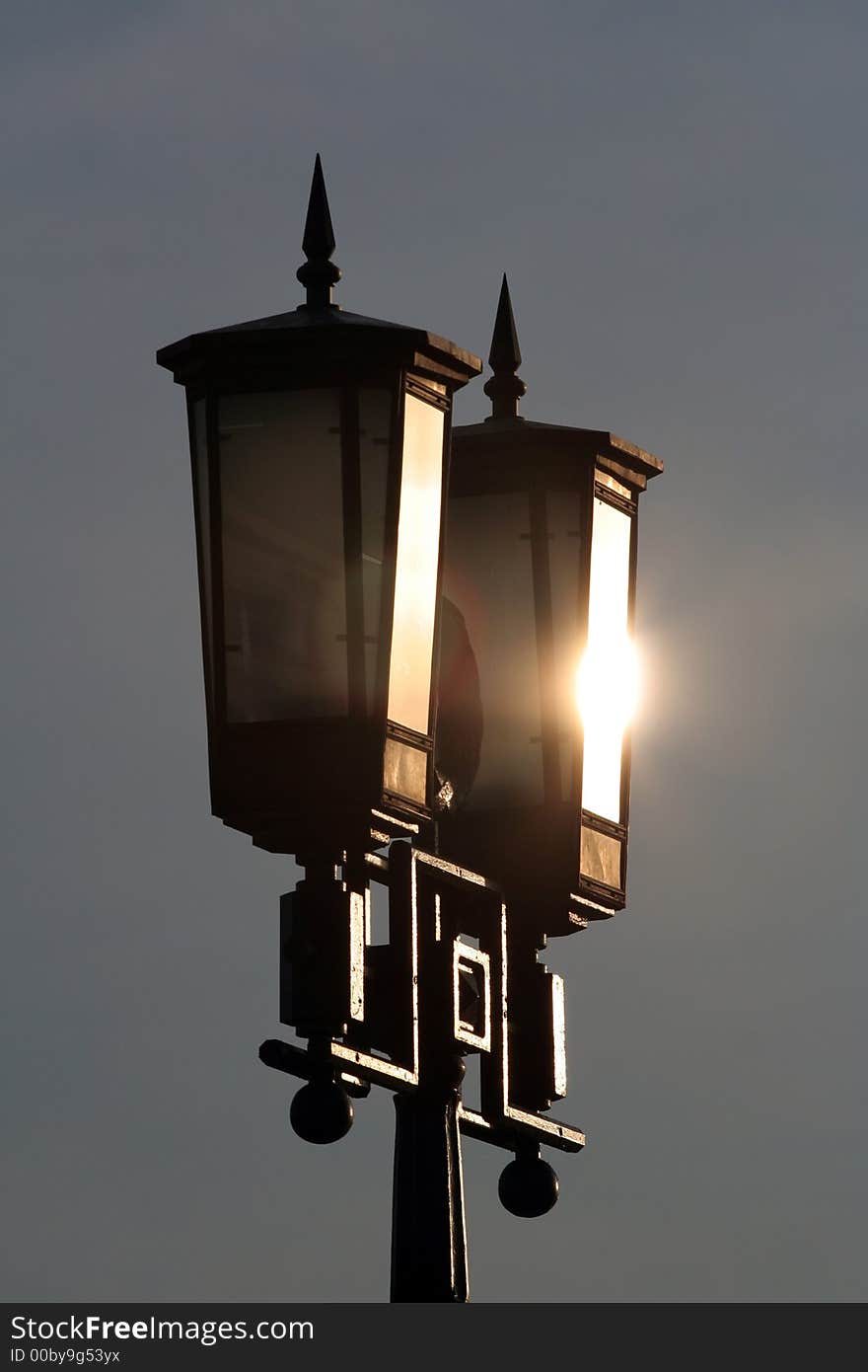 Street lamp in park with sun glare