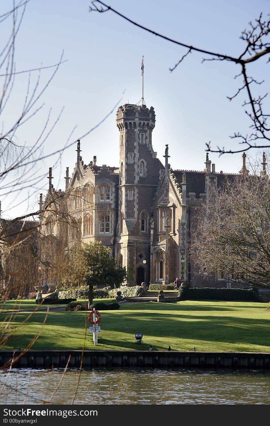 Winter sky over a Gothic Mansion on the Banks of a River in England