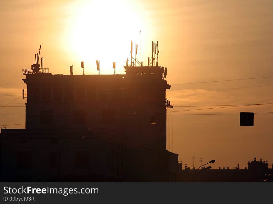 Buiding with combined antennas on the roof at sunrise. Buiding with combined antennas on the roof at sunrise.