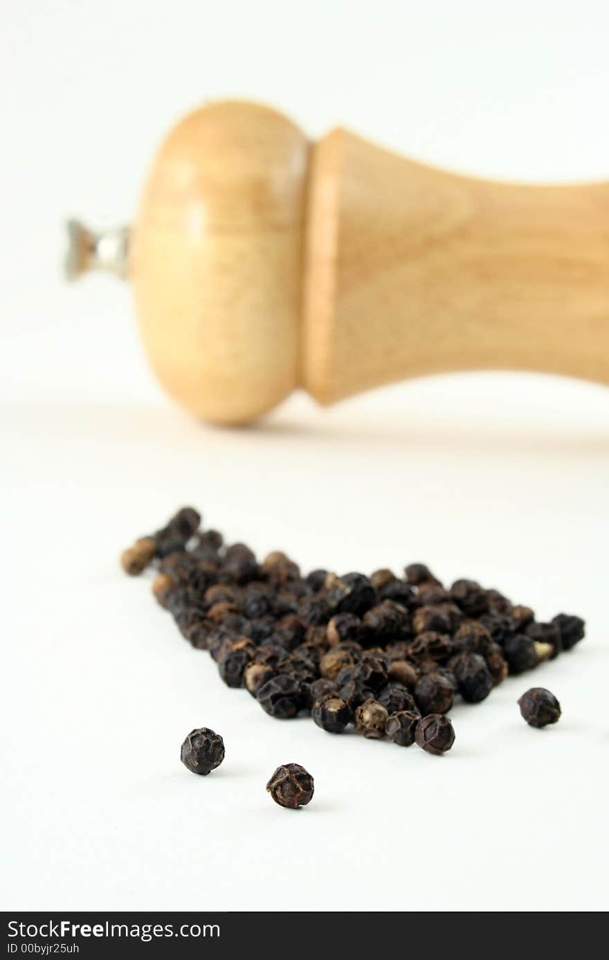 Black pepper corns with peppermill, narrow focus. Black pepper corns with peppermill, narrow focus