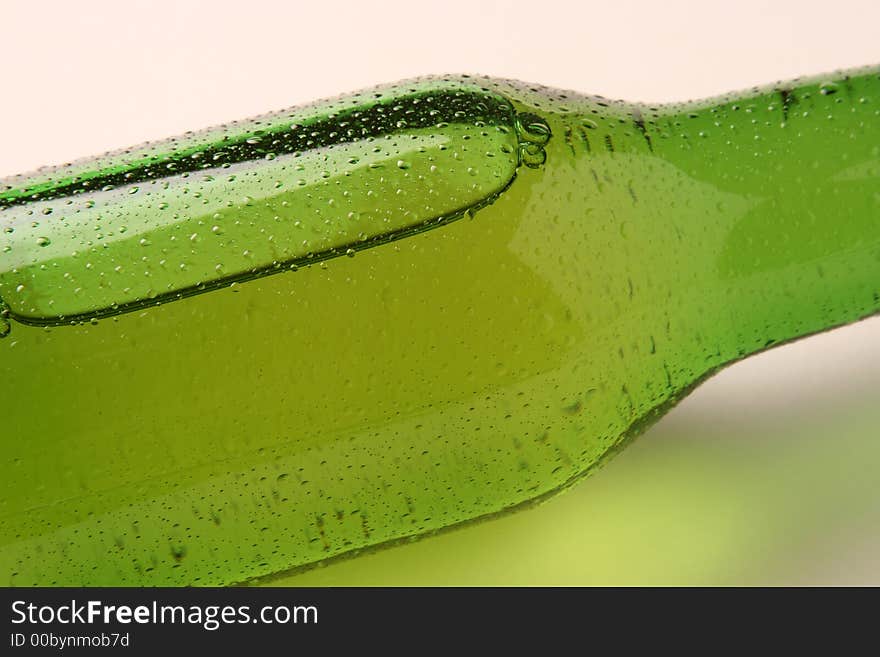 A cold bottle of beer on its side. A cold bottle of beer on its side