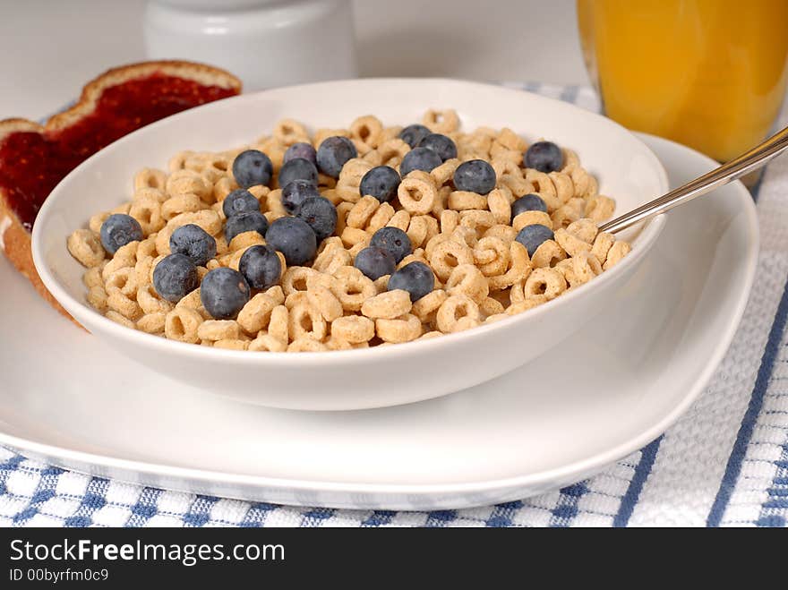 Oat cereal with blueberries and spoon, toast with raspberry jam. Oat cereal with blueberries and spoon, toast with raspberry jam