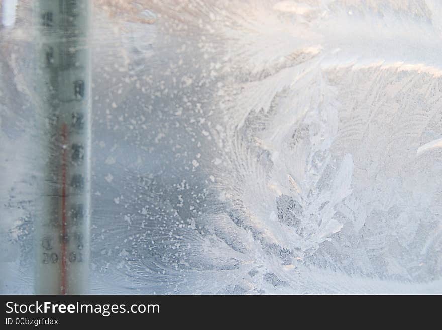 Beautiful frosty window with thermometer, good background for greeting-cards, thermometer is out of focus, focal point on frosting. Beautiful frosty window with thermometer, good background for greeting-cards, thermometer is out of focus, focal point on frosting.