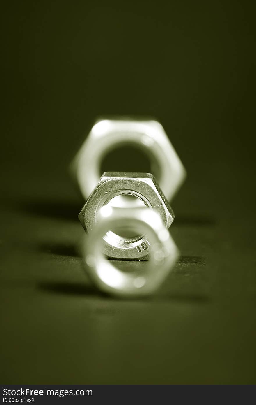 Tree steel nuts on black background turned into sepia. Tree steel nuts on black background turned into sepia.