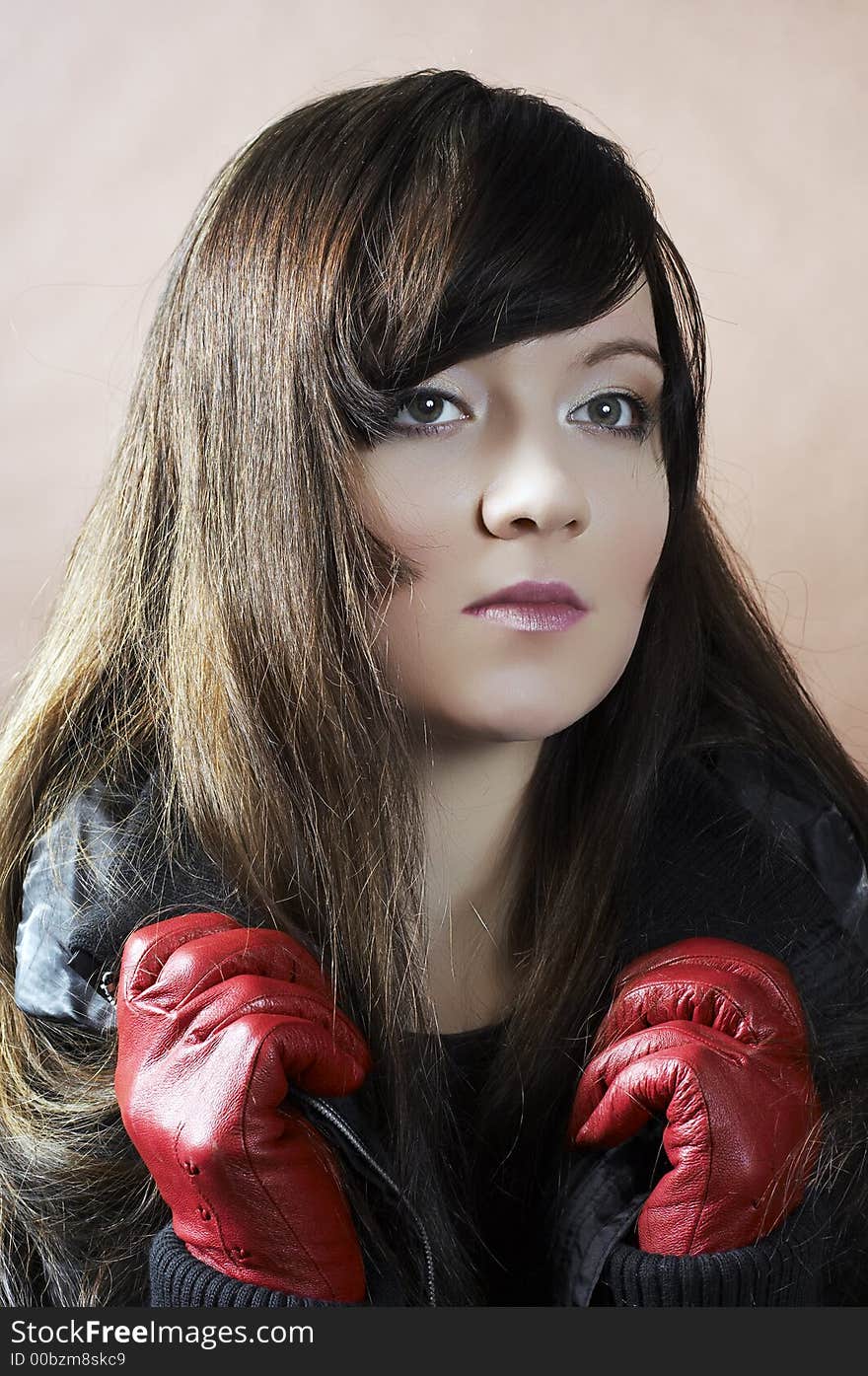 Portrait of the girl in a black jacket and red gloves