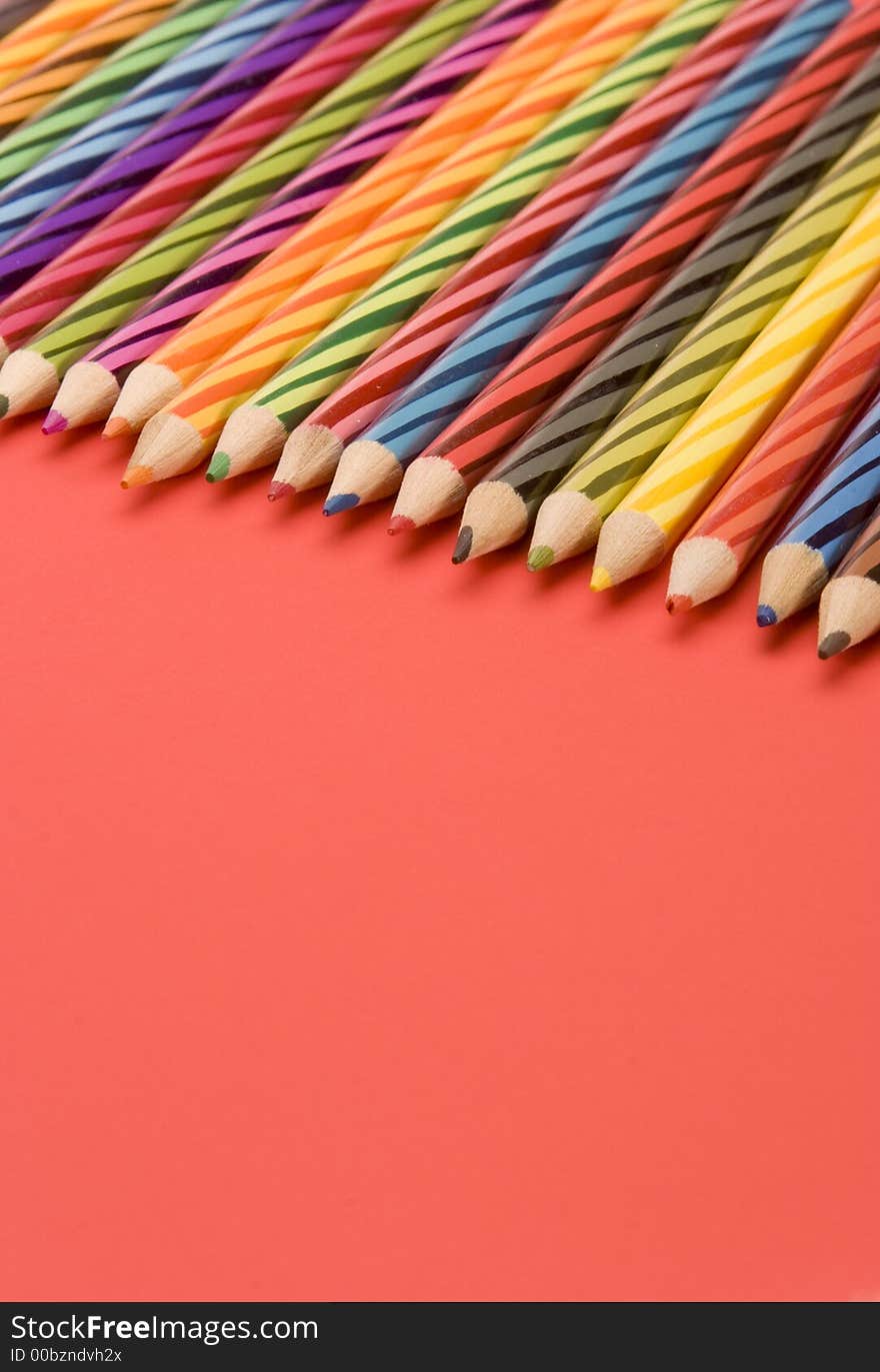 Coloured Pencils set against a Plain Background.