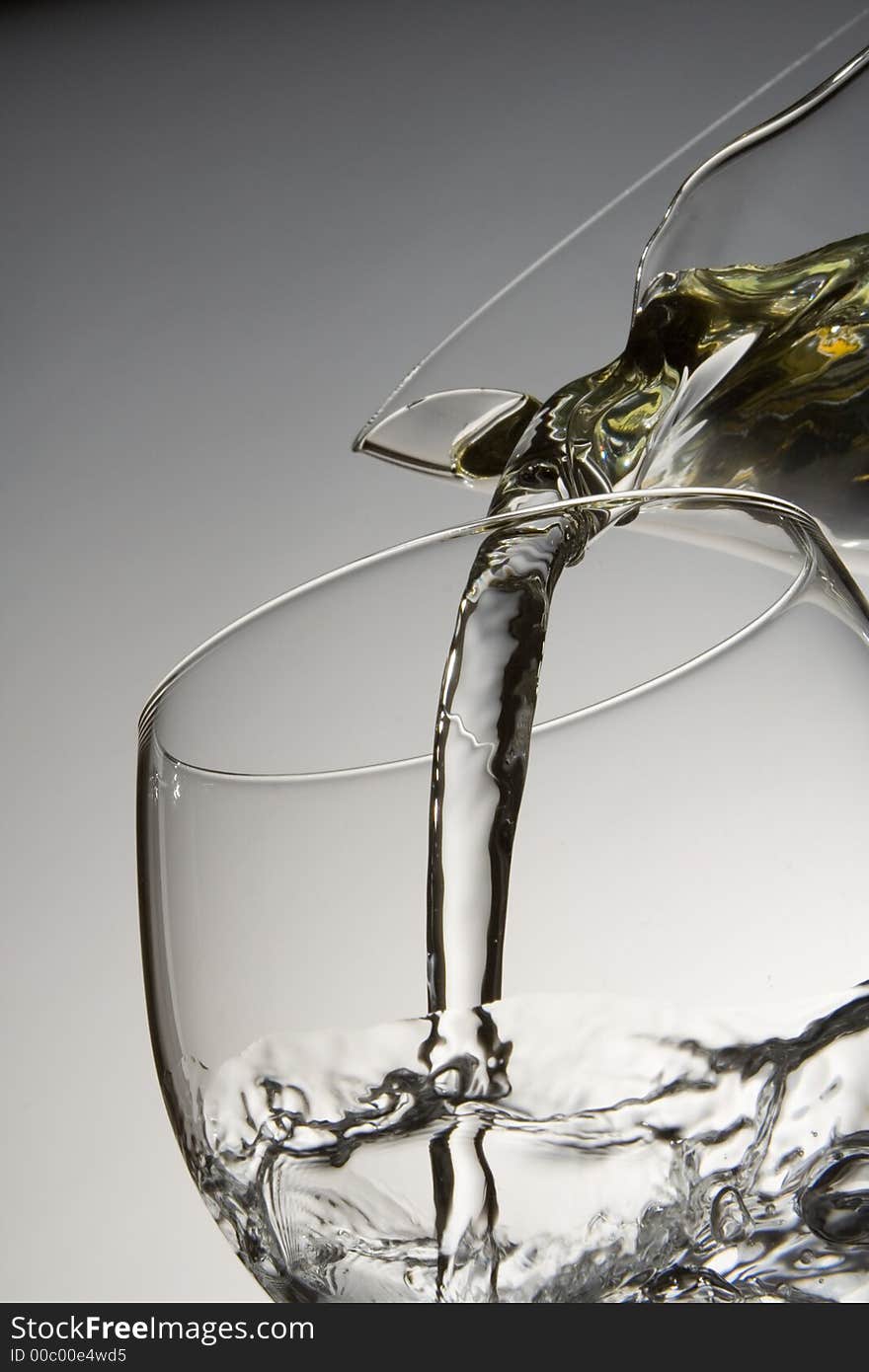 Water pouring from a decanter into a glass. Water pouring from a decanter into a glass