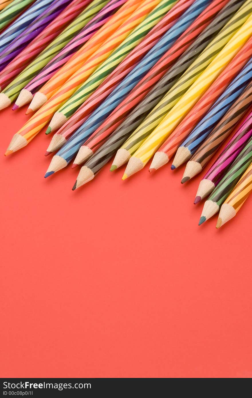 Coloured Pencils set against a Plain Background.