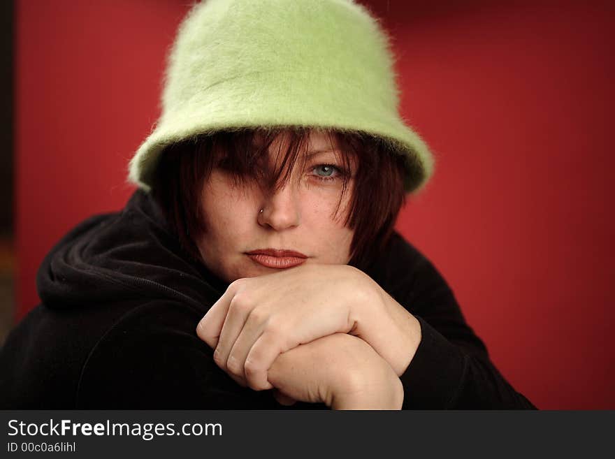 Cute read head woman with a green Hat over red background. Cute read head woman with a green Hat over red background