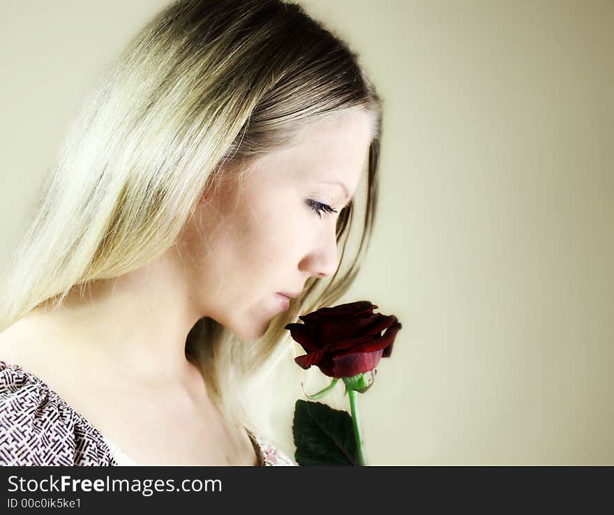 Portrait of a fresh, beautiful young blond woman with a red rose in her hand - valentine ´s day