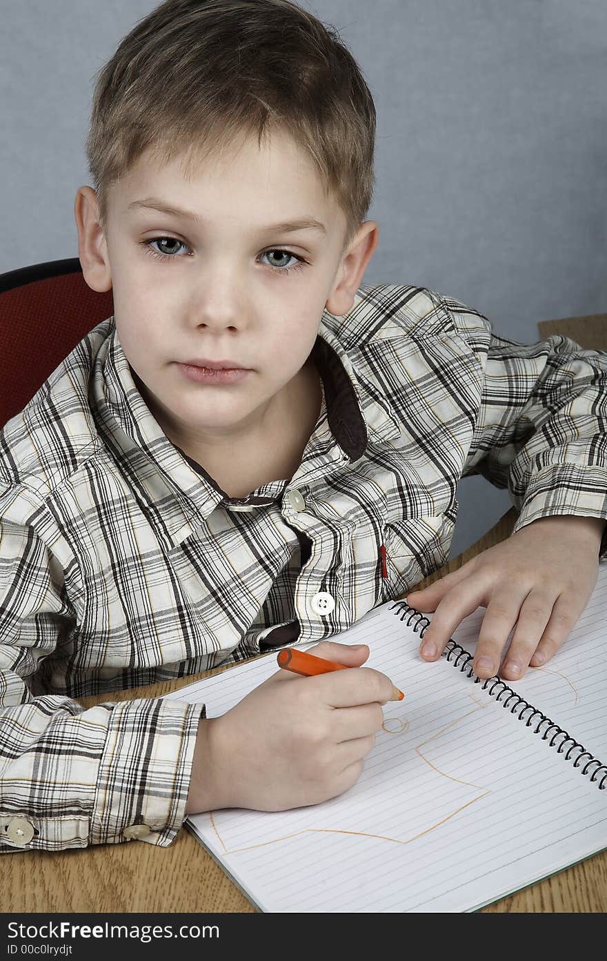 Serious drawing boy with notepad and pencil. Serious drawing boy with notepad and pencil