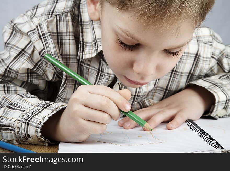 Serious drawing boy with notepad and pencil. Serious drawing boy with notepad and pencil