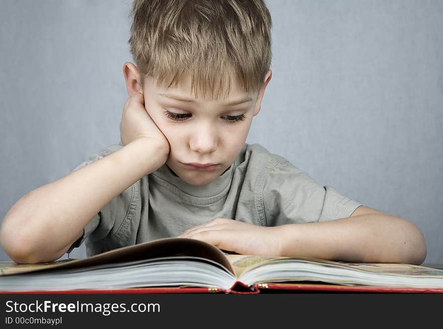 Little sad boy with big book. Little sad boy with big book