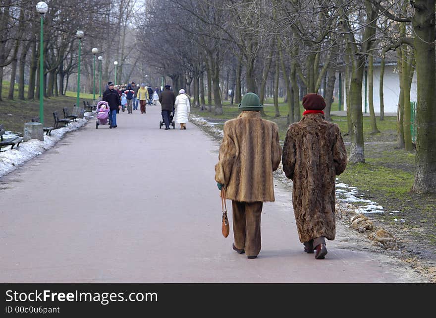 Two women in furs walking in the park