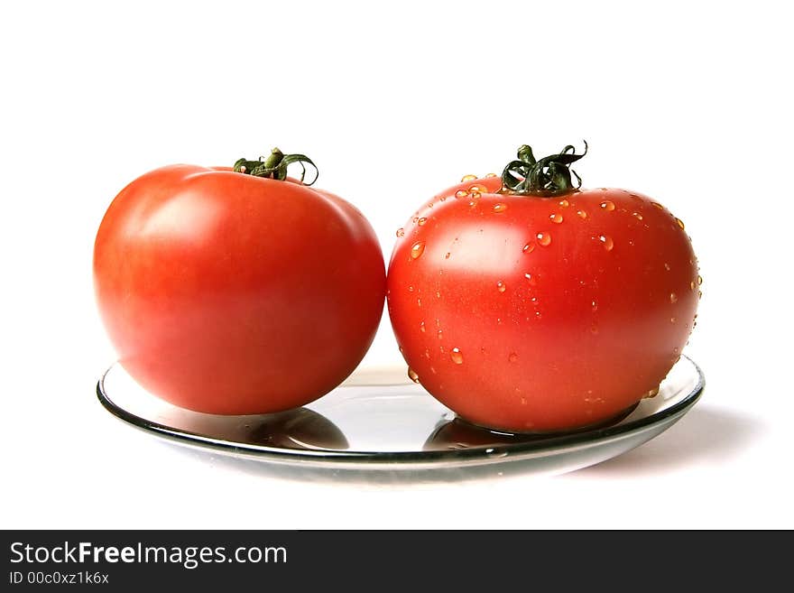 Dry and wet tomatoes at the plate on a white background