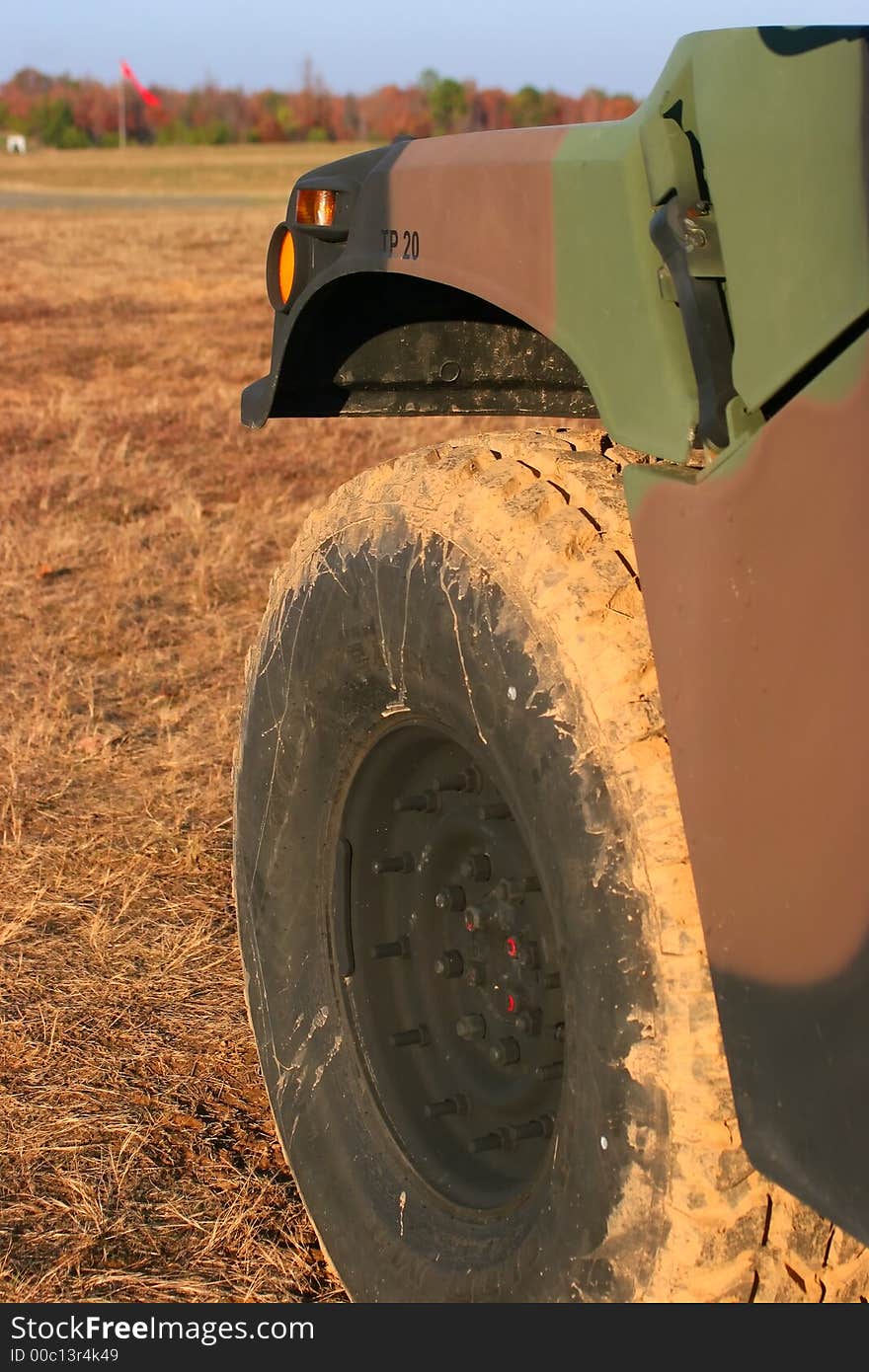 The muddy wheel of a military vehicle from a low angle. The muddy wheel of a military vehicle from a low angle