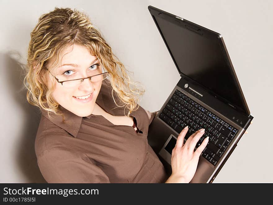 Businesswoman with glasses holding laptop computer. Businesswoman with glasses holding laptop computer