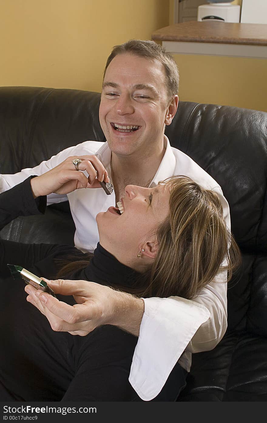 Portrait of couple on couch eating chocolate