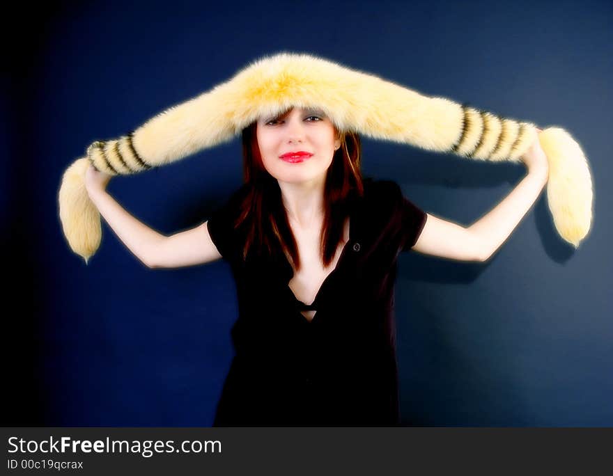 Portrait of a smiling young girl holding a furry yellow boa draped across her forehead.  Color enhancement.  Horizontal format.  . Portrait of a smiling young girl holding a furry yellow boa draped across her forehead.  Color enhancement.  Horizontal format.