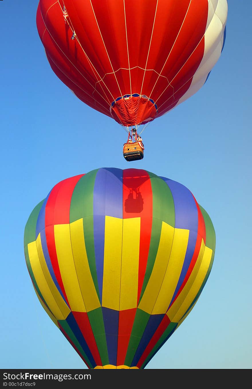 Colorful, ascending balloons, ascending very close to each other. The shadow of one is on the other. This image was taken at the 2005 Johnson Space Center Ballunar festival in the Clear Lake Texas area. Colorful, ascending balloons, ascending very close to each other. The shadow of one is on the other. This image was taken at the 2005 Johnson Space Center Ballunar festival in the Clear Lake Texas area.