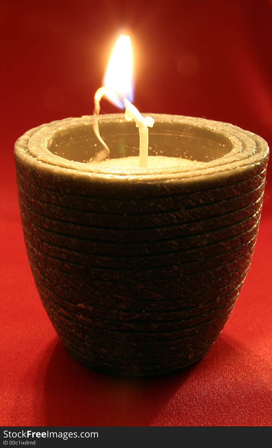 Candle with red silk background.