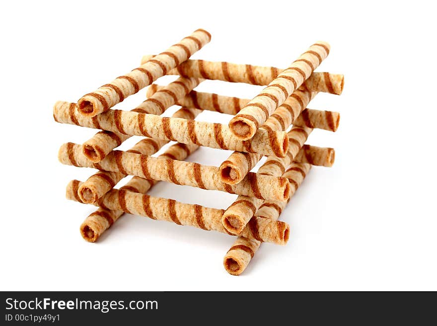 Heap of striped wafer tubules with the chocolate cream, isolated