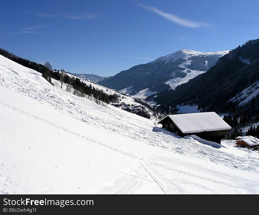 Mountain valley with chalet and snow