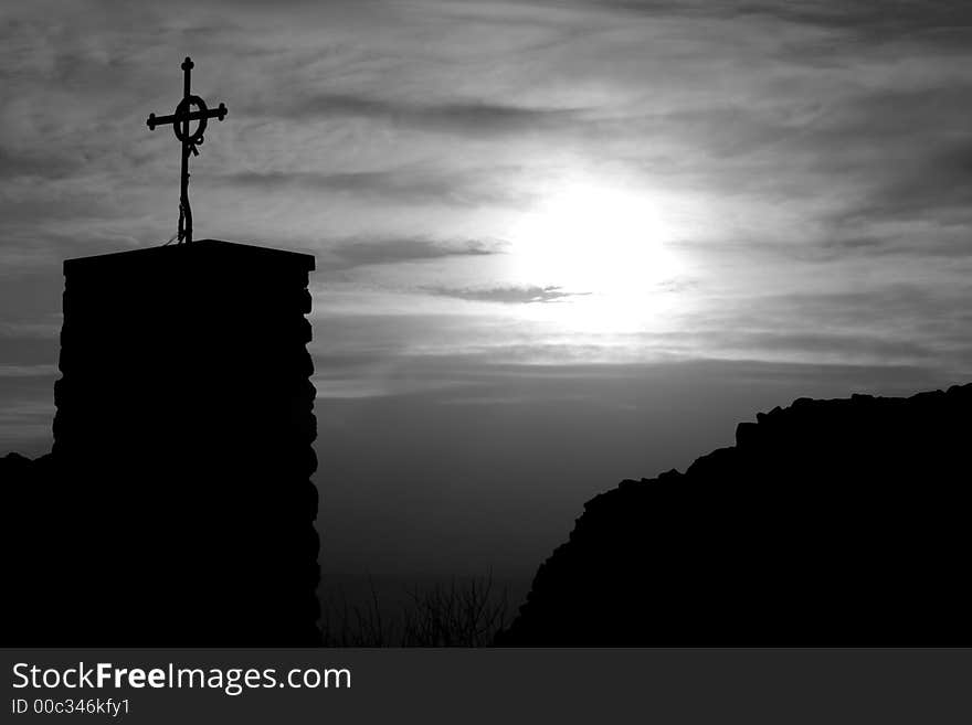 Cross by the sunset in old castle