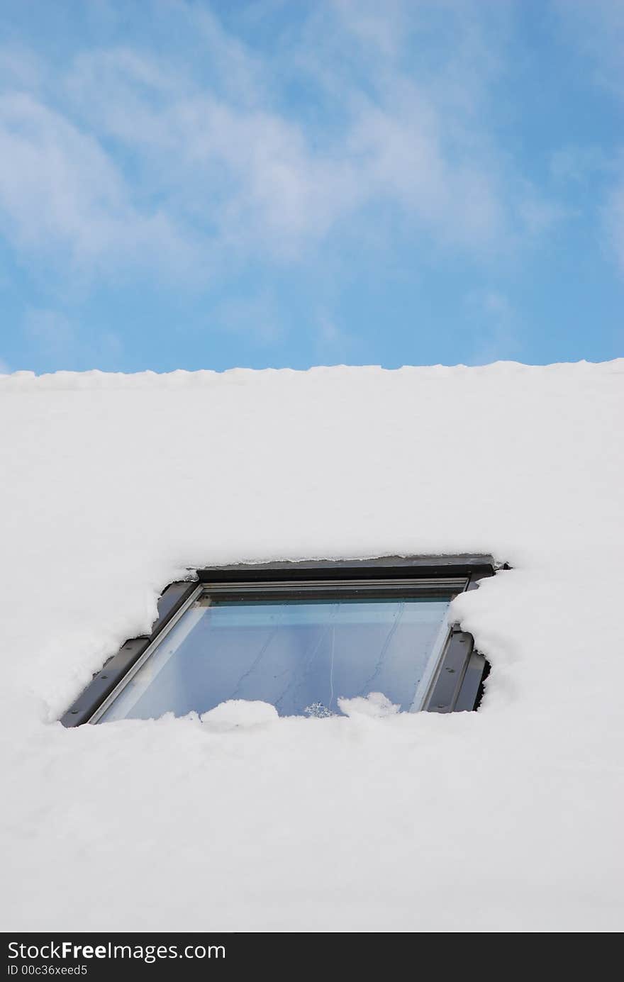 Window on a roof full of snow under blue sky. Window on a roof full of snow under blue sky