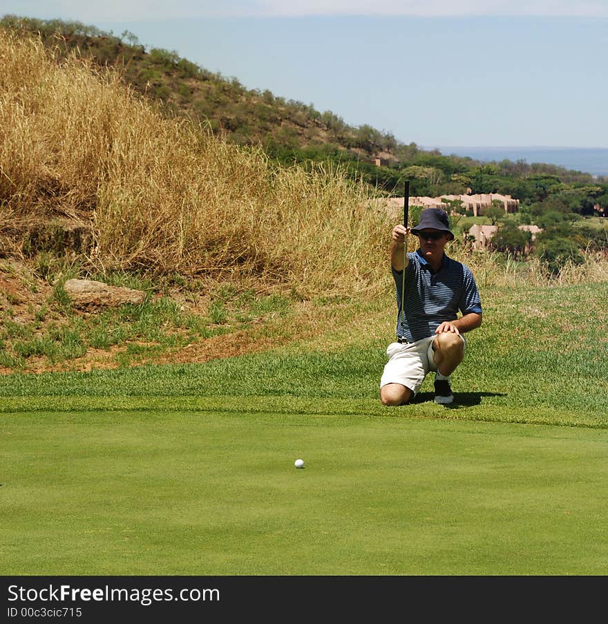 Golfer estimating a line for a putt. Golfer estimating a line for a putt.