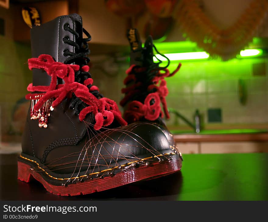 A pair of black boots redecorated for party with wire and red ties. A pair of black boots redecorated for party with wire and red ties