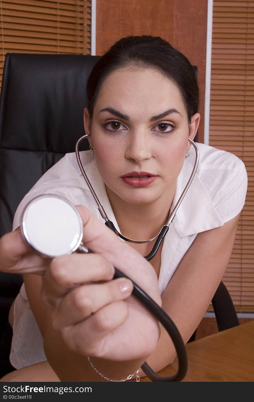 Brunette doctor holding the stethoscope to the camera. Brunette doctor holding the stethoscope to the camera