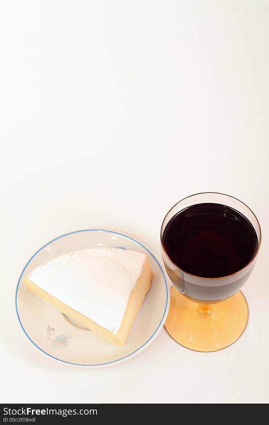 French cheese on wood trencher with red wine cup isolated on white. French cheese on wood trencher with red wine cup isolated on white