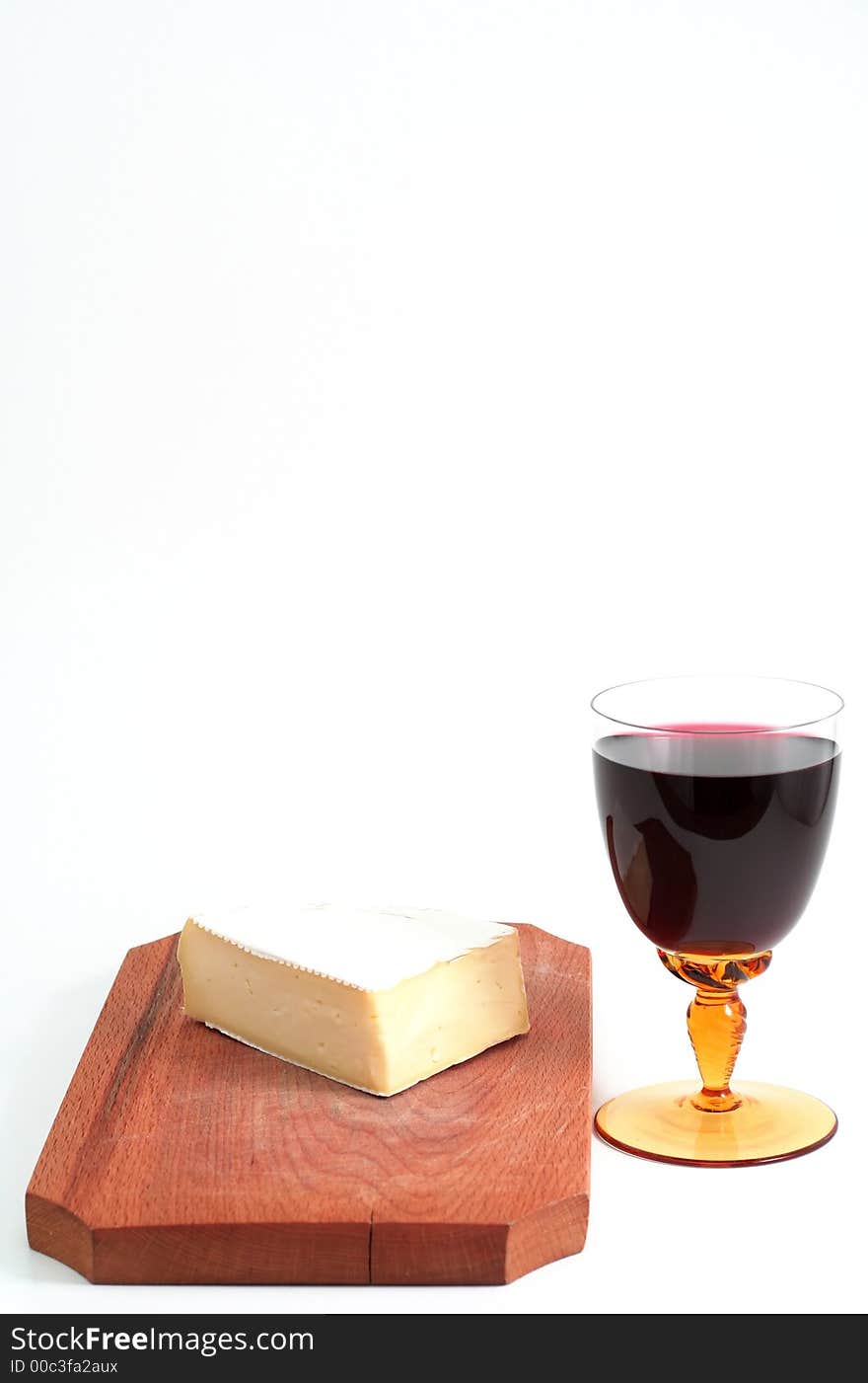 French cheese on wood trencher with red wine cup isolated on white. French cheese on wood trencher with red wine cup isolated on white