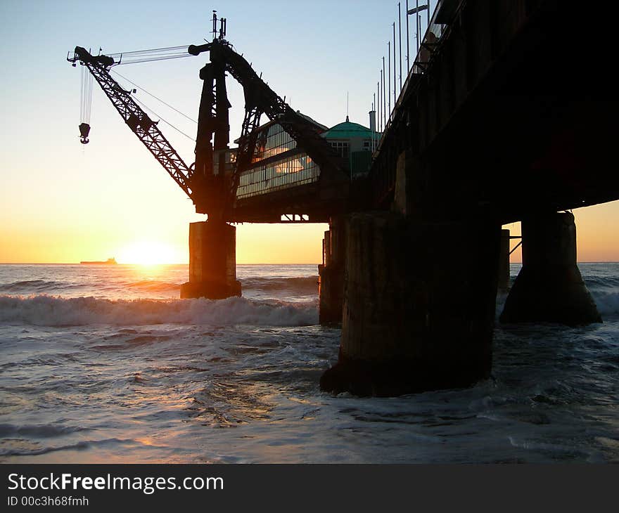 A sunset at a Chilean beach with an abandoned industrial crane. A sunset at a Chilean beach with an abandoned industrial crane