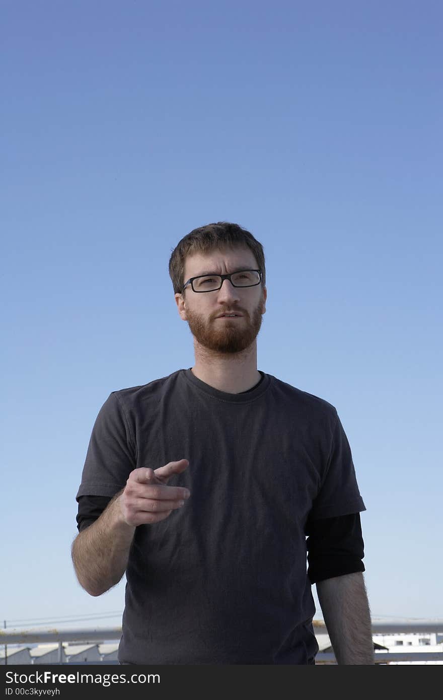 Man speaking and pointing in bright sunlight. Man speaking and pointing in bright sunlight.